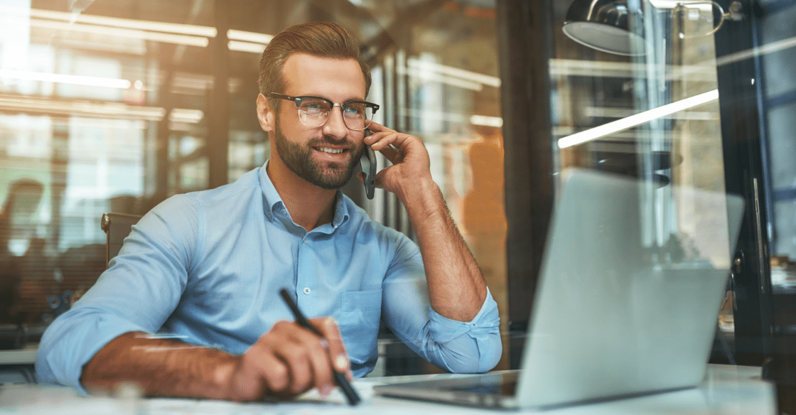 Professional man talking on the phone while working on his laptop