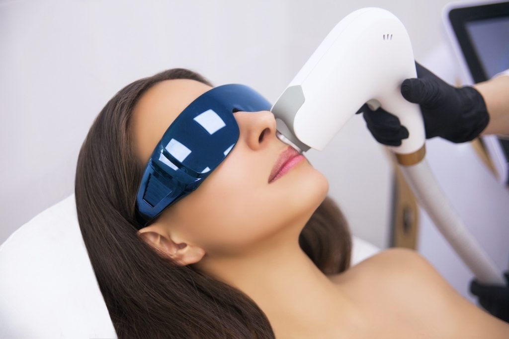 Anti-aging procedures. Skin care concept. Woman receiving facial beauty treatment, removing pigmentation at cosmetic clinic. Intense pulsed light therapy. IPL. Rejuvenation, photo facial therapy.