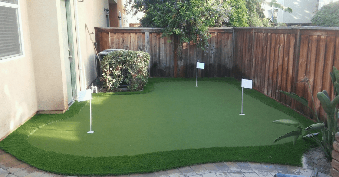 artificial turf putting turf in a backyard