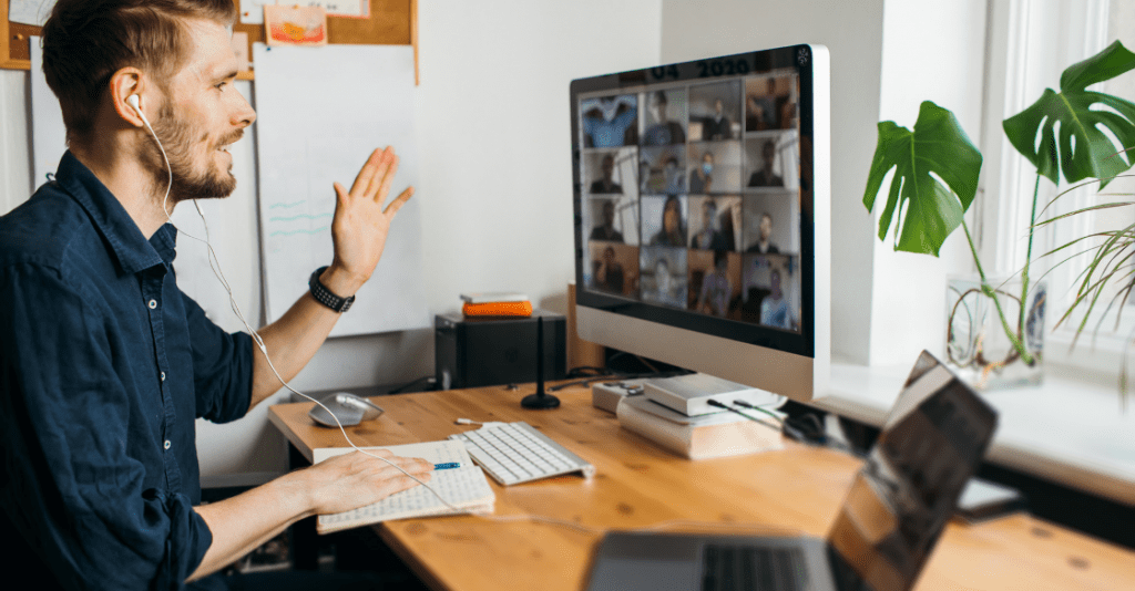 A man works from home while having a virtual team meeting.