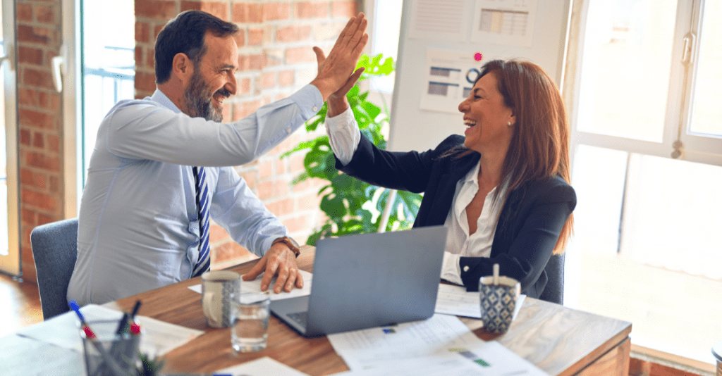 Happy employees high-fiving during the app development process.