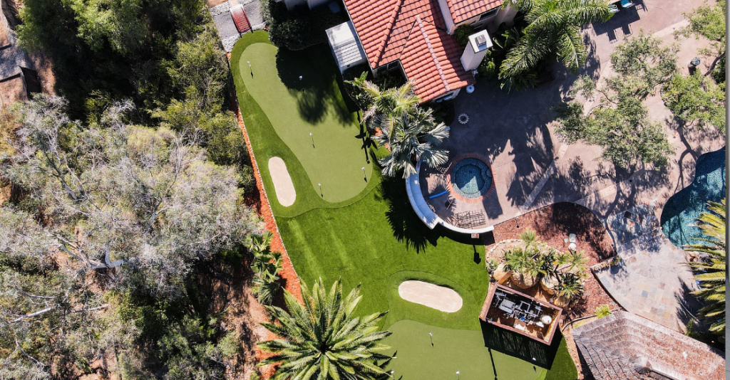 Bird's eye view of a landscaped backyard with a artificial grass putting green