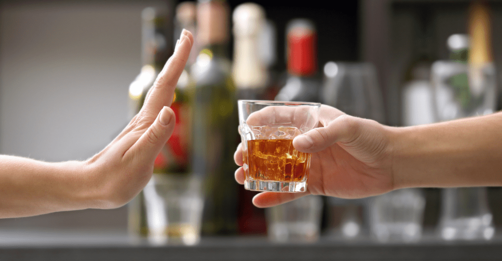 Person holding out hand to refuse alcohol after Botox